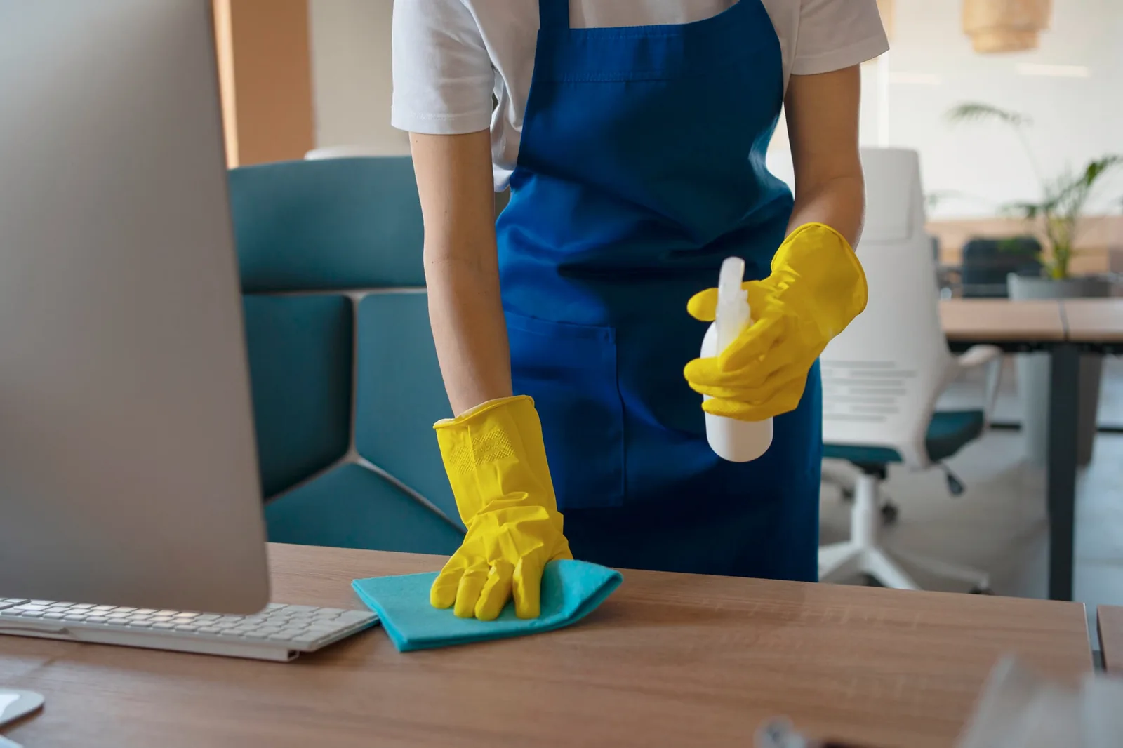 Cleaner vacuuming carpet by floor to ceiling office windows